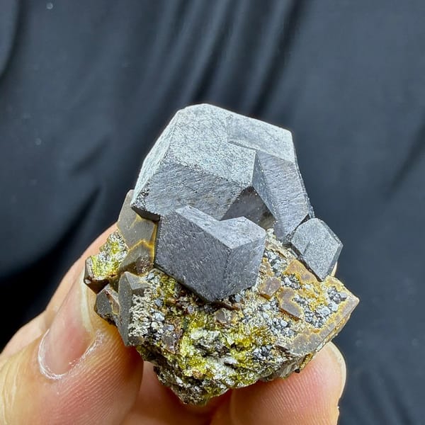 Large grey magnetite crystal on garnet and calcite from Inner Mongolia, China