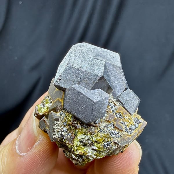 Large grey magnetite crystal on garnet and calcite from Inner Mongolia, China, view 6 of 6