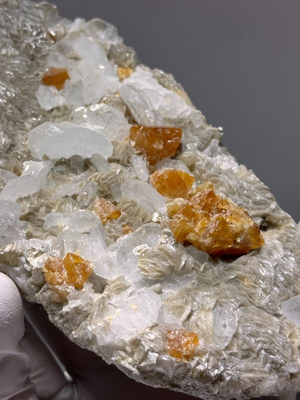 Mica plate with scheelite, aquamarine and fluorite from Xuebaoding, Sichuan, China, top view