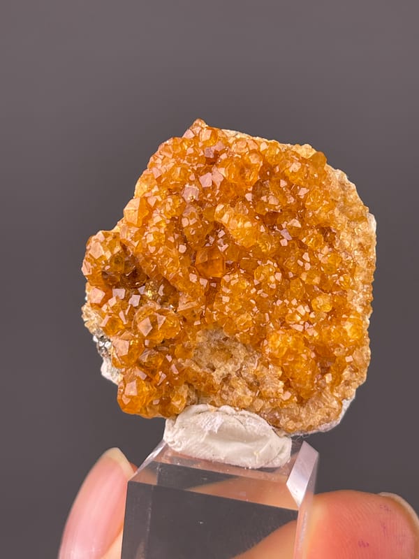 Orange-brown crystal druse visible on spessartine garnet specimen from Yunxiao, Fujian, China