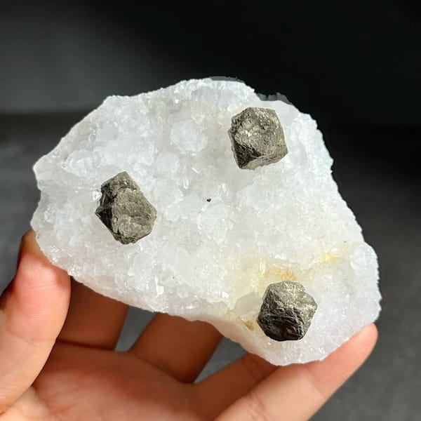 Three ball-shaped pyrite crystals on white quartz plate from Guangxi, China