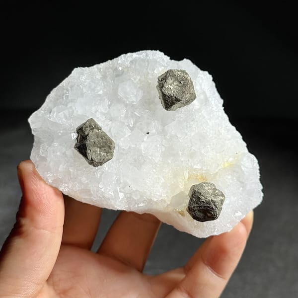 Three ball-shaped pyrite crystals on white quartz plate from Guangxi, China, view 9 of 12