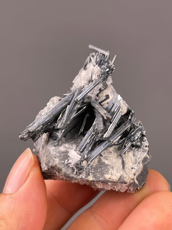 Steel-gray striated radiating blades visible on Stibnite with Calcite specimen from Lengshuijiang, Hunan, China