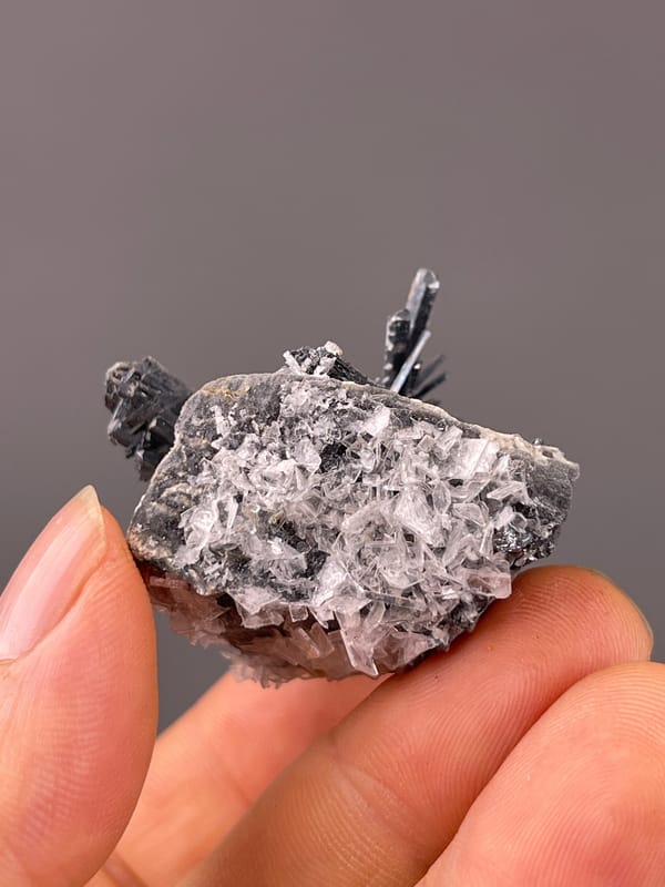 Stibnite with Calcite specimen from Lengshuijiang, Hunan, China displaying steel-gray striated radiating blades