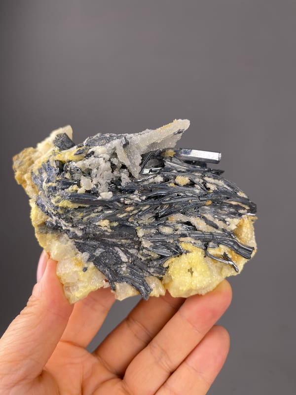 Stibnite specimen from Lengshuijiang, Hunan, China featuring steel-gray blades with pale crystals