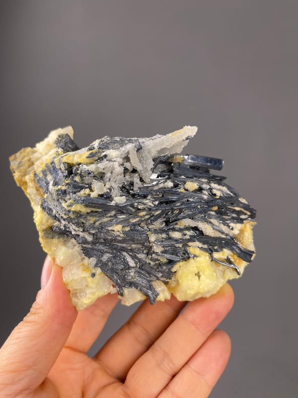 Stibnite specimen from Lengshuijiang, Hunan, China showing steel-gray blades with pale crystals