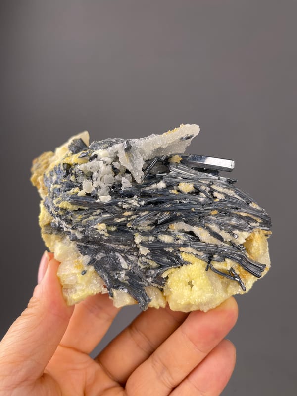 Stibnite specimen from Lengshuijiang, Hunan, China, defined by steel-gray blades with pale crystals