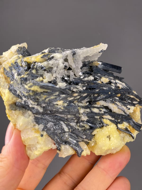 Stibnite specimen from Lengshuijiang, Hunan, China presenting steel-gray blades with pale crystals