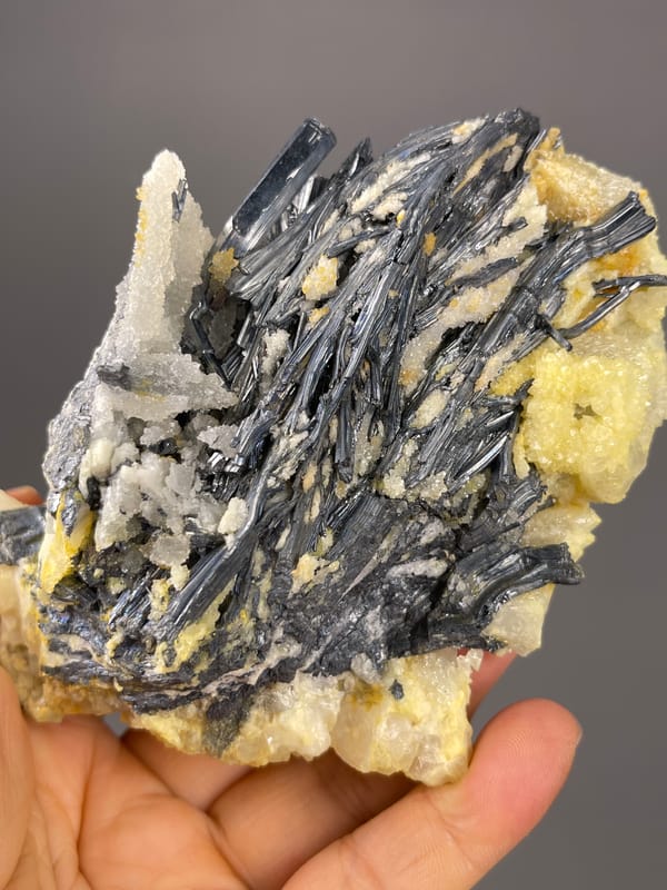 Stibnite specimen from Lengshuijiang, Hunan, China, characterized by steel-gray blades with pale crystals