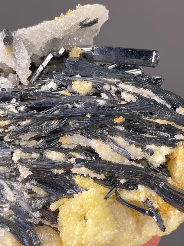 Stibnite specimen from Lengshuijiang, Hunan, China bearing steel-gray blades with pale crystals