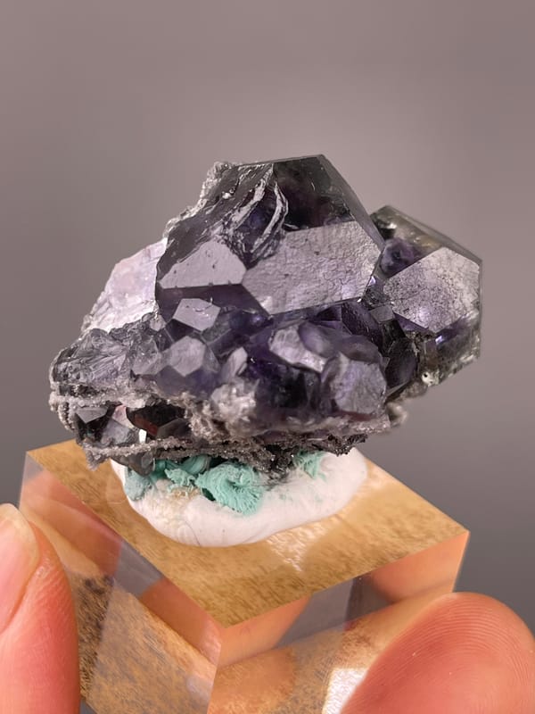 Dark purple fluorite with green patch visible on tanzanite-blue fluorite specimen from Yongchun, Fujian, China
