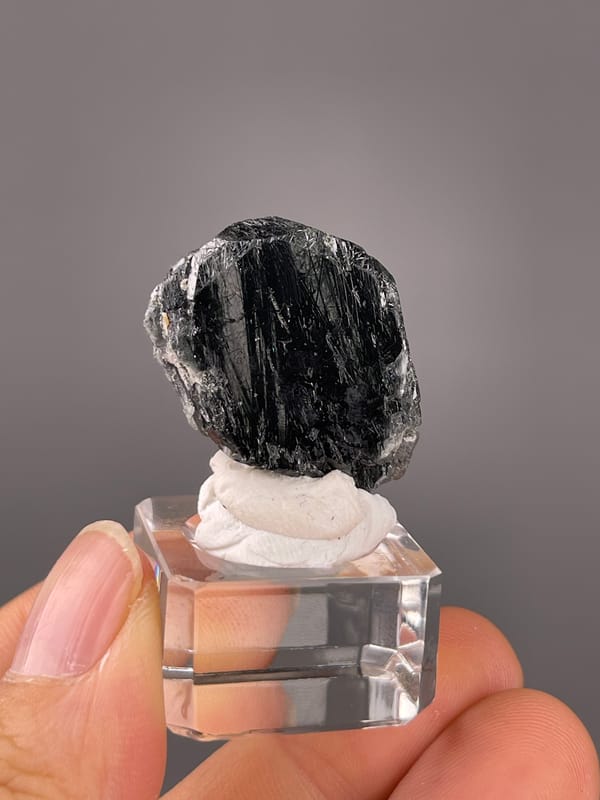 Tourmaline from Brazil: black rounded face crossed by close parallel striations.