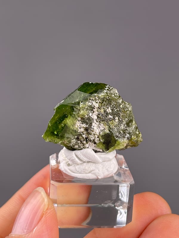 Tourmaline from Brazil: angled green face with a rough pale center.