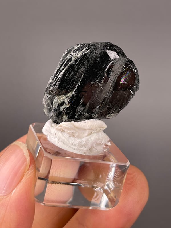 Tourmaline from Brazil: angled dark surface with narrow bright parallel lines.