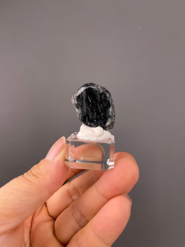 Tourmaline from Brazil: whole black specimen on a clear display cube.