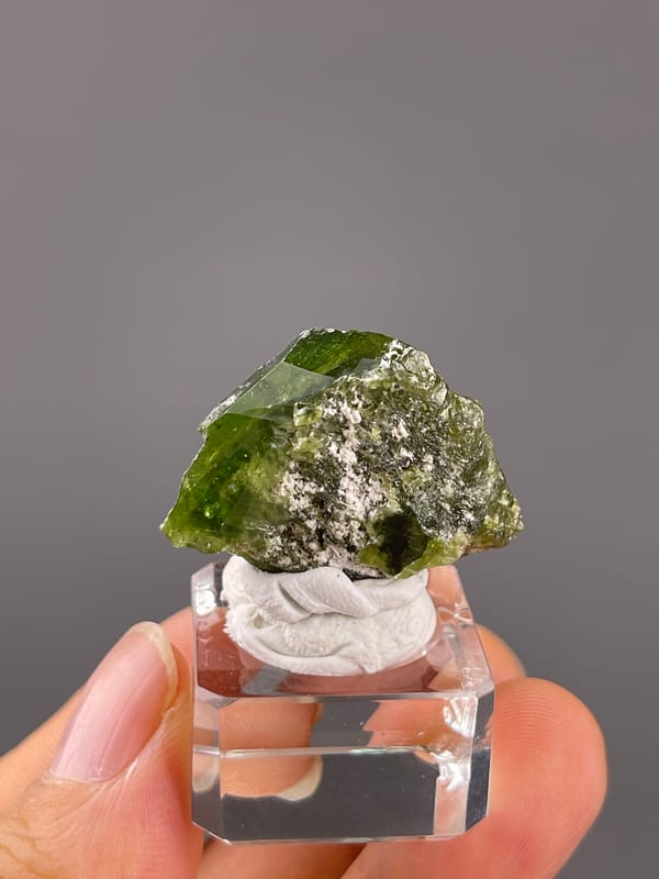 Tourmaline from Brazil: front angle showing a dark green upper edge and rough lighter center.