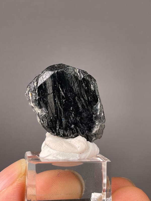 Tourmaline from Brazil: close dark face with bright striation lines near the edge.