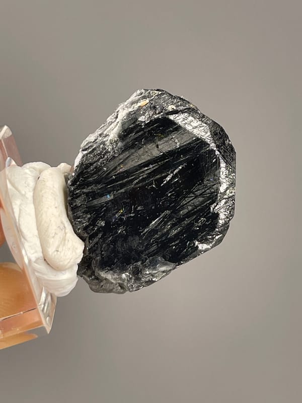 Tourmaline from Brazil: horizontal close view of black linear faces and uneven margin.