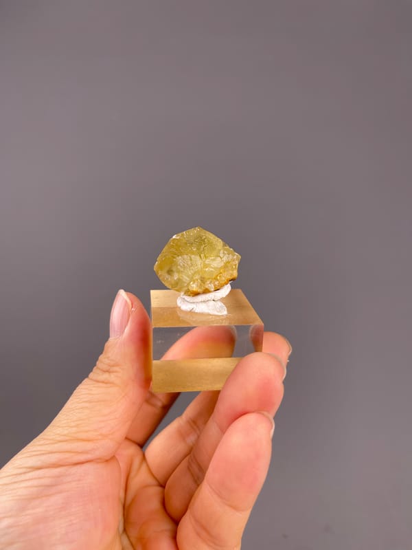Unidentified specimen from Daye, Hubei, China: whole yellow crystal on its clear display cube.