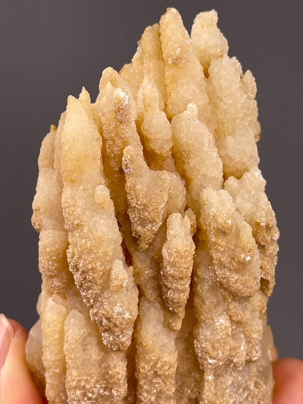 Unidentified specimen from Yunnan, China: detail of finely granular surfaces on pointed beige growths.