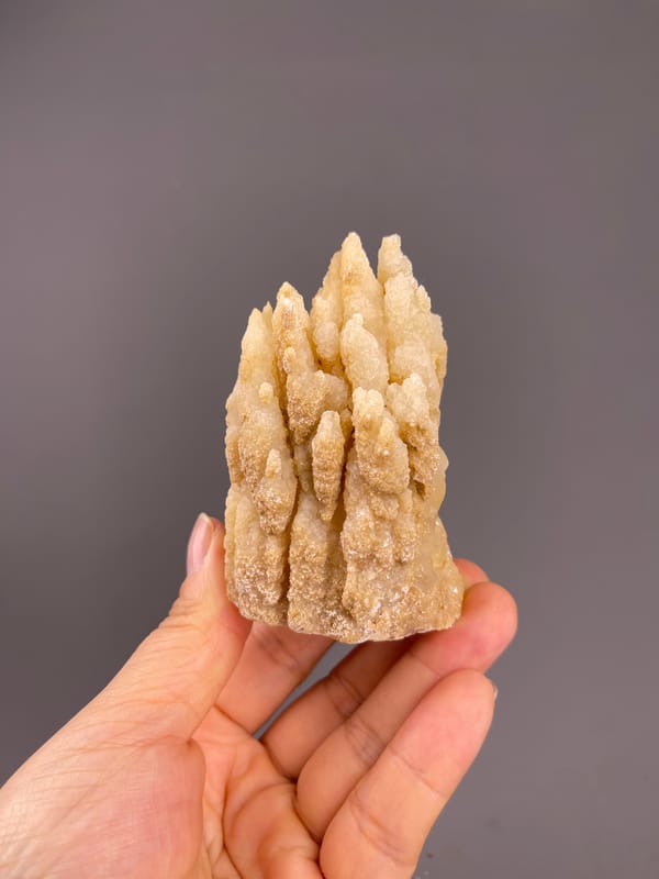 Unidentified specimen from Yunnan, China: whole upright specimen held across the fingers.