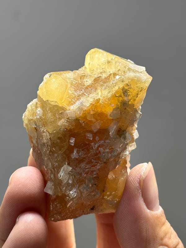 Unusual honey scheelite floater with calcite from Xuebaoding, Sichuan, China, close-up of the crystal faces