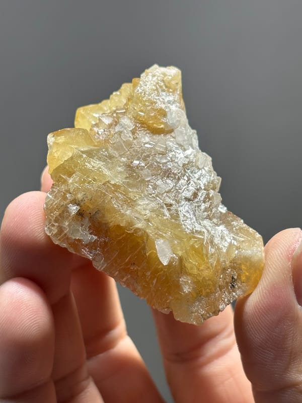 Unusual honey scheelite floater with calcite from Xuebaoding, Sichuan, China, top view