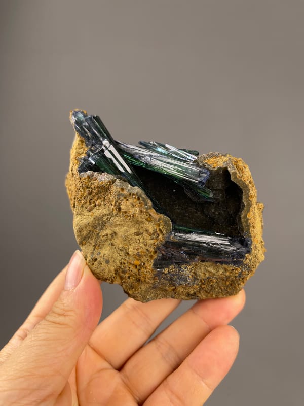 Vivianite specimen from Brazil featuring dark green-black striated blades