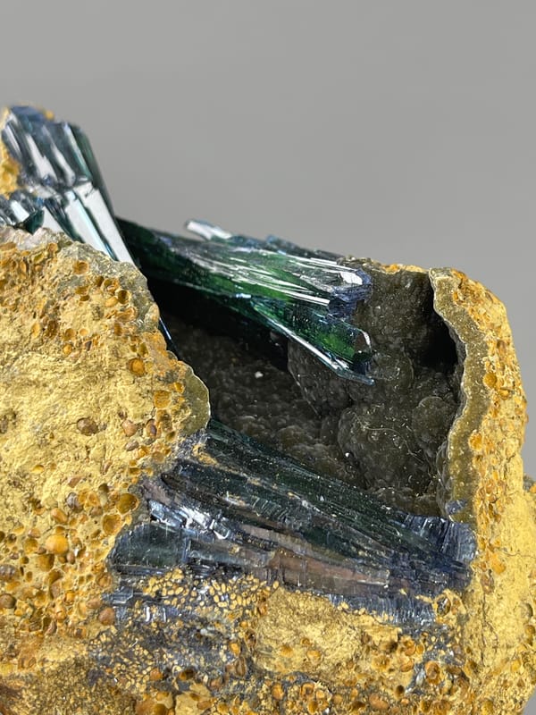 Dark green-black striated blades on natural vivianite specimen from Brazil