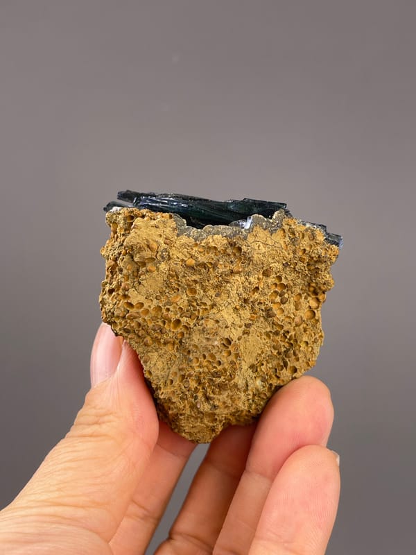 Vivianite from Brazil: broad porous matrix face beneath a thin dark upper edge.