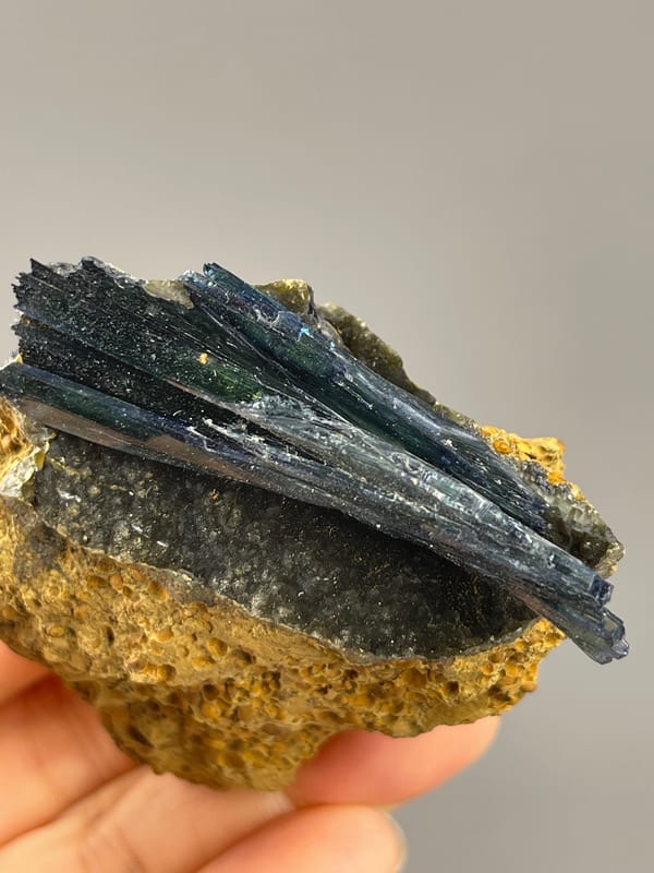 Vivianite from Brazil: top view of long green black blades with narrow reflective faces.