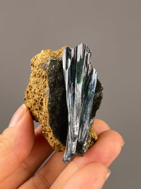 Vivianite from Brazil: upright crystal side showing bright reflections on staggered blades.
