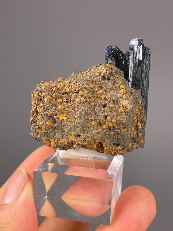 Black striated blades on brown matrix visible on vivianite specimen from Brazil