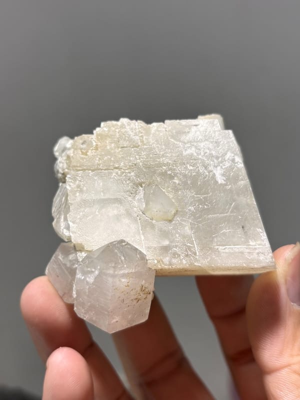 White calcite block with clear quartz crystal from Xuebaoding, Sichuan, China, close-up of the crystal faces