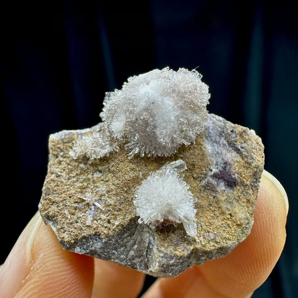 Two white chrysanthemum creedite sprays on grey rock from Guizhou, China