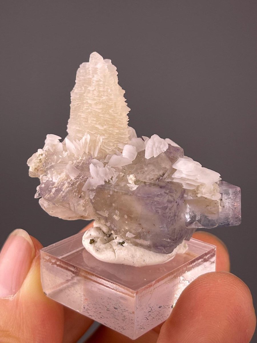 Natural pale purple and green fluorite with white calcite on matrix, a MyMineralBox specimen, showing that real fluorite color is usually soft rather than candy-bright